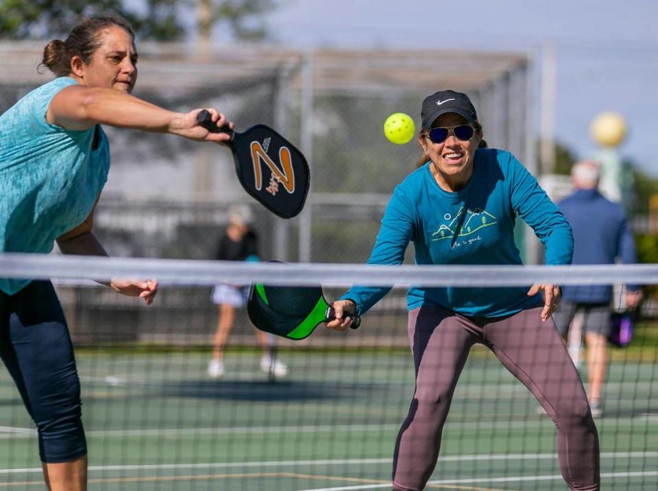 Fabiola Perez, 49, left, and Maria Elena Guinand, 57, play a game of pickleball at Suniland Park in Pinecrest, Florida on Friday, January 14, 2022.