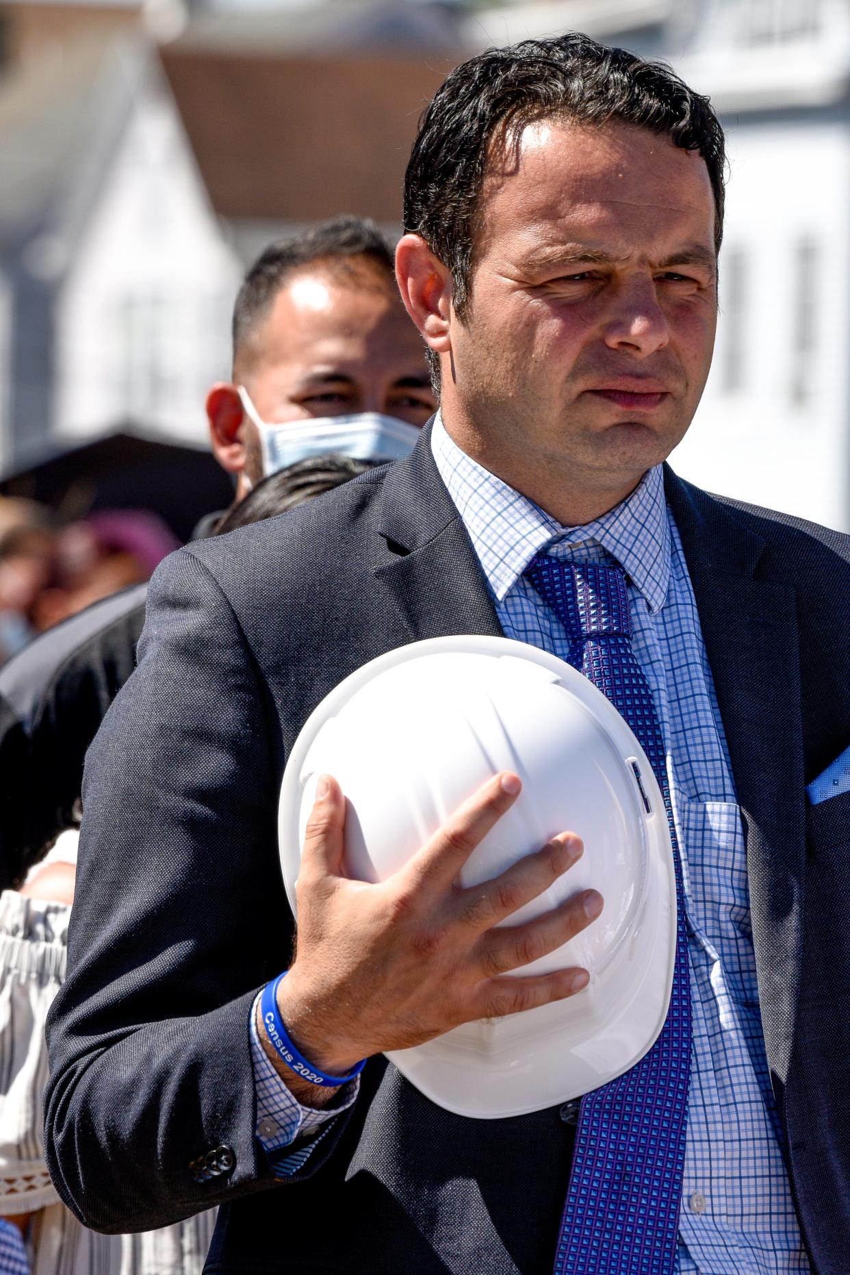 A fire destroyed the Paterson armory in 2015. Paterson officials gather at the site of the armory on Thursday August 20, 2020 to break ground on a new project led by developer Charles Florio to transform the lot into 138 apartments, commercial space as well as a police substation. Paterson Mayor André Sayegh holds a hard hat to his chest. 