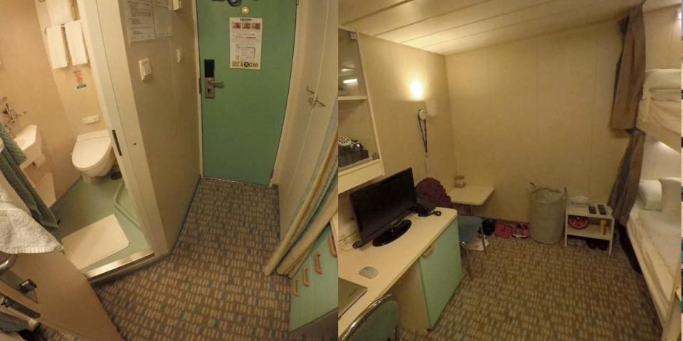A small room on a cruise ship showing the entrance to a bathroom, bunk beds, a desk, and a door