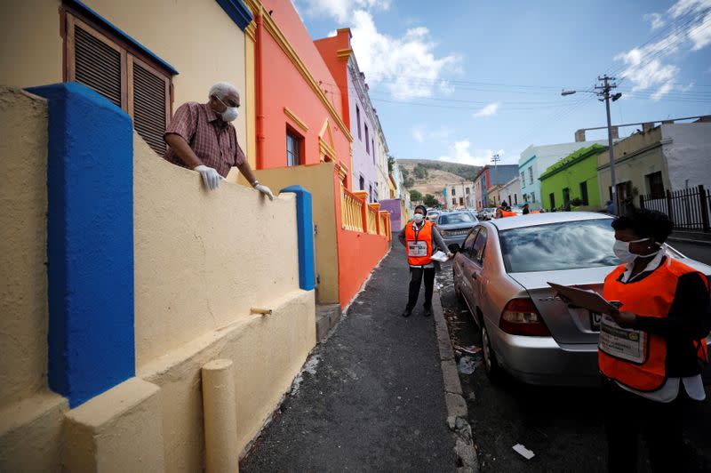 A health worker talks to residents as they conduct screening during the 21-day nationwide lockdown aimed at limiting the spread of coronavirus disease (COVID-19) in Bo Kaap, Cape Town