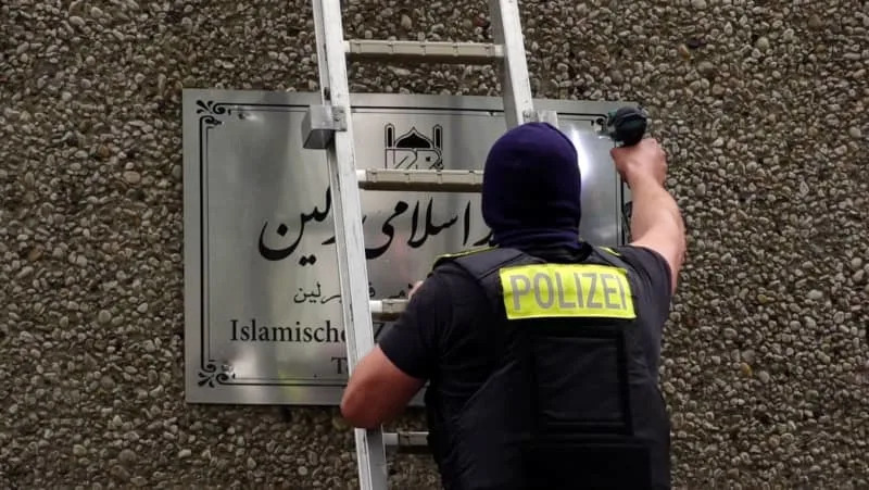 A police officer removes a sign from the Islamic Center Berlin in Ordensmeisterstrasse. Sven Käuler/TNN/dpa