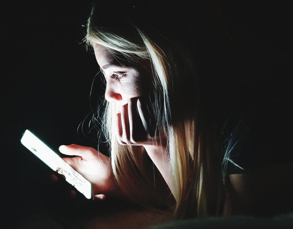 girl on phone in dark