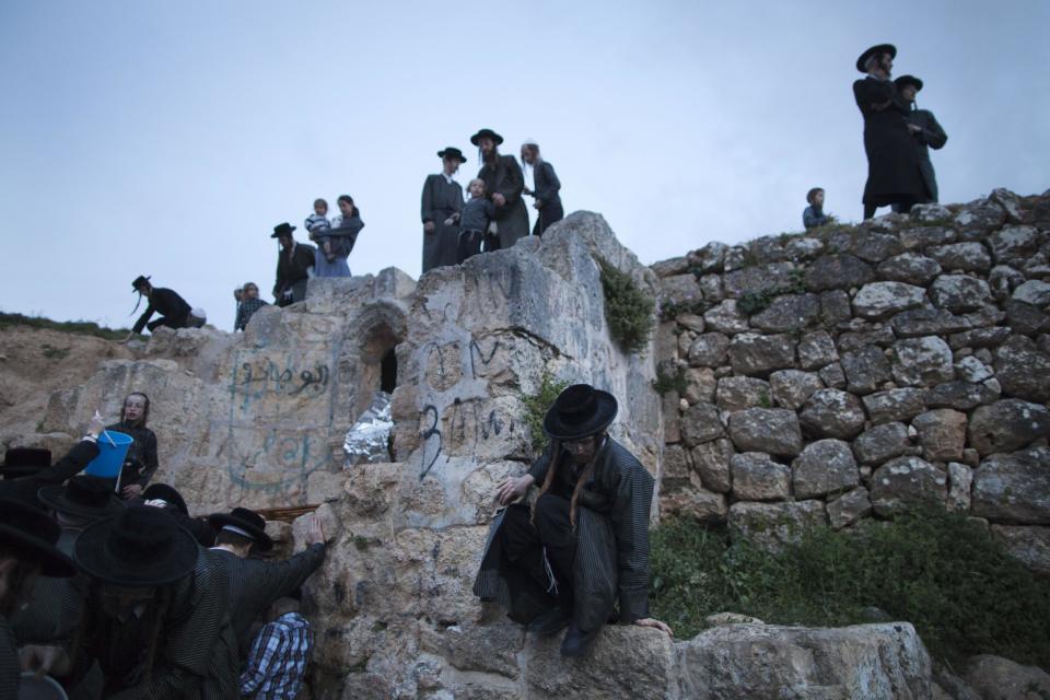 Ultra-Orthodox Jews collect water to make matza during the Maim Shelanoo ceremony at a mountain spring, near Jerusalem, Sunday, April 13, 2014. The water is used to prepare the traditional unleavened bread for the high holiday of Passover which begins Monday.(AP Photo/Dan Balilty)