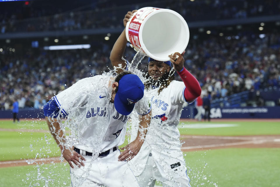 Toronto Blue Jays relief pitcher Jordan Romano, left, is doused with water by Vladimir Guerrero Jr. after they defeate the Philadelphia Phillies in a baseball game in Toronto on Tuesday, Aug. 15, 2023. (Nathan Denette/The Canadian Press via AP)