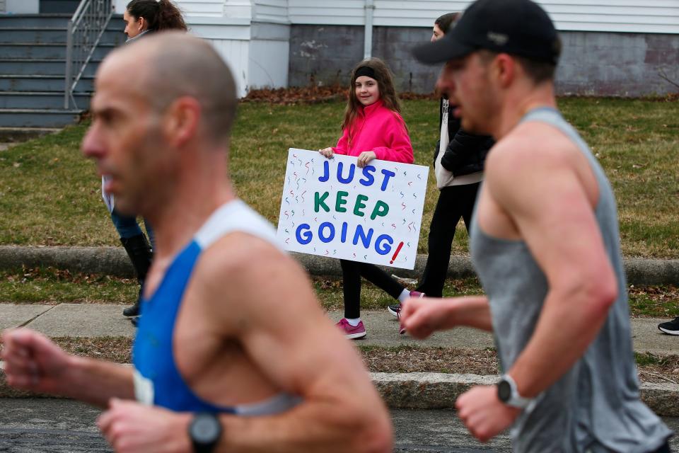A young girl urges runners making their way down Rockdale Avenue at the 2024 New Bedford Half Marathon.