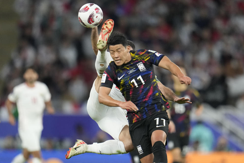 South Korea's Hwang Hee-chan, centre, and Jordan's Ehsan Haddad, rear, vie for the ball during the Asian Cup semifinal soccer match between South Korea and Jordan at Ahmad Bin Ali Stadium in Al Rayyan, Qatar, Tuesday, Feb. 6, 2024. (AP Photo/Aijaz Rahi)