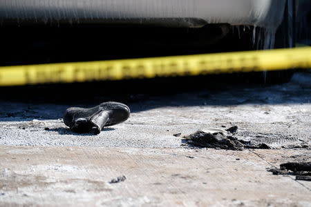 A shoe is seen on the driveway behind the police line which ropes around the house where seven children died from a fatal structure fire in the community of Spryfield in Halifax, Nova Scotia, Canada, on February 20, 2019. REUTERS/Ted Pritchard