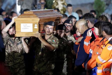 Italian soldiers carry a coffin at the end of funeral service for victims of the earthquake that levelled the town in Amatrice, central Italy, August 30, 2016. REUTERS/Max Rossi