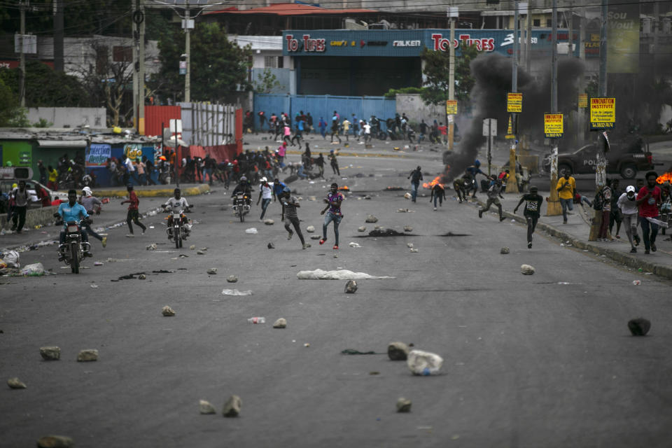 FILE - People run after clashes erupted during a protest against fuel price hikes and to demand that Haitian Prime Minister Ariel Henry step down, in Port-au-Prince, Haiti, Friday, Sept. 16, 2022. The 2021 kidnapping of 17 missionaries underscored a deteriorating security situation that has only worsened in the past year, with some Haitian leaders calling for foreign troop deployments to help break the paralyzing grip of gang activity and protests. (AP Photo/Odelyn Joseph, File)