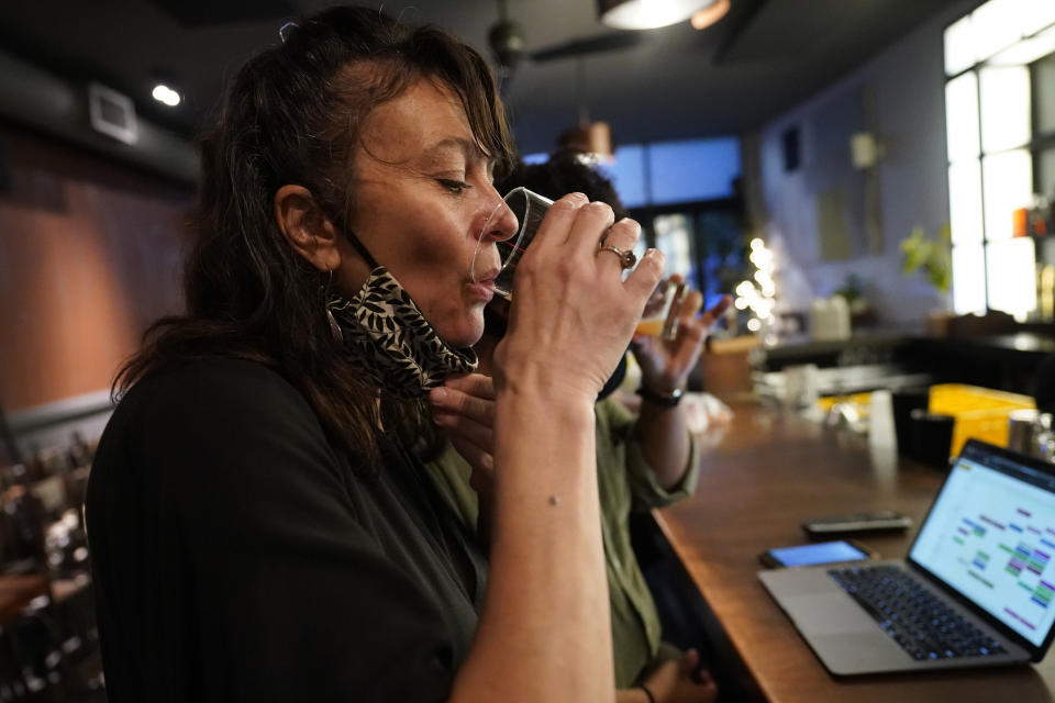 Mama Fox bar and restaurant owner Samantha DiStefano samples a new drink for the fall season, Tuesday, Sept. 29, 2020, in New York, while meeting with her manager to discuss serving patrons indoors. New York opens to indoor dining Wednesday, but capacity is limited to 25%. U.S. restaurants are moving warily into fall, hoping their slow recovery persists despite the new challenge of chilly weather and a pandemic that keeps adding to its casualties. (AP Photo/Kathy Willens)