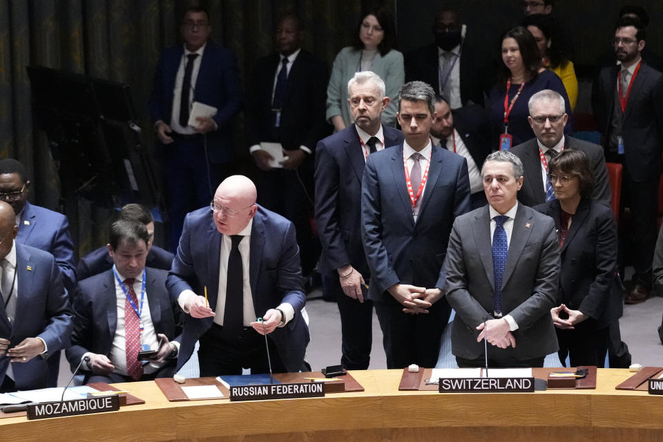 Russian ambassador to the United Nations Vasily Nebenzya, center left, speaks while rising for a moment of silence at United Nations headquarters, Friday, Feb. 24, 2023. (AP Photo/Seth Wenig)