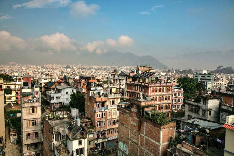 The skyline of Kathmandu, Nepal, showing buildings and surrounding mountains.