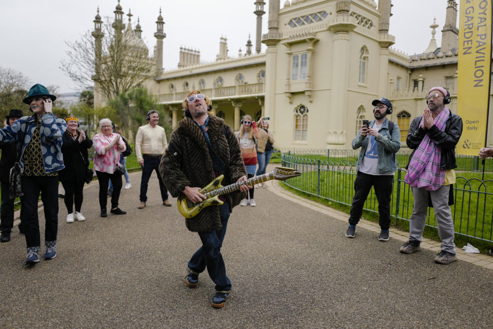 People take part in a silent disco event outside the Brighton Dome, in Brighton, England, Saturday, April 6, 2024. Fans are celebrating 50 years since ABBA won its first big battle with “Waterloo.” A half century ago on Saturday, April 6, the Swedish quartet triumphed at the 1974 Eurovision Song Contest with the peppy love song. (AP Photo/Alberto Pezzali)