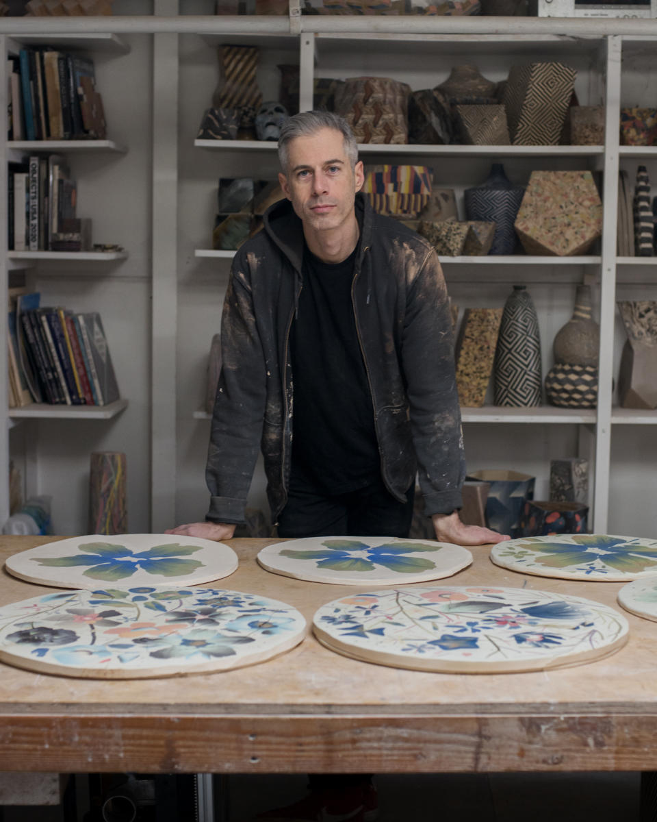 Ceramicist Cody Hoyt with the “pizzas” he created as source material for the Calico Wallpaper collection Botanica.