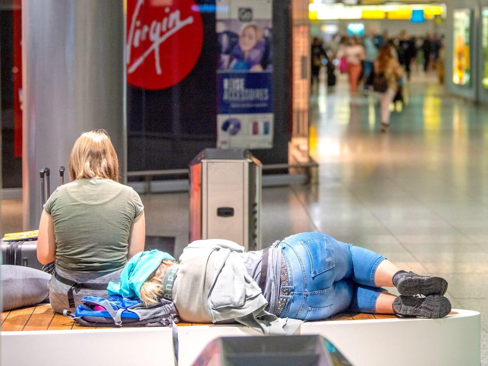 14 July 2022, Lower Saxony, Hanover: A traveler sleeps on a bench at Hannover Airport. In Lower Saxony, the summer vacations run from July 14 to August 24, 2022.