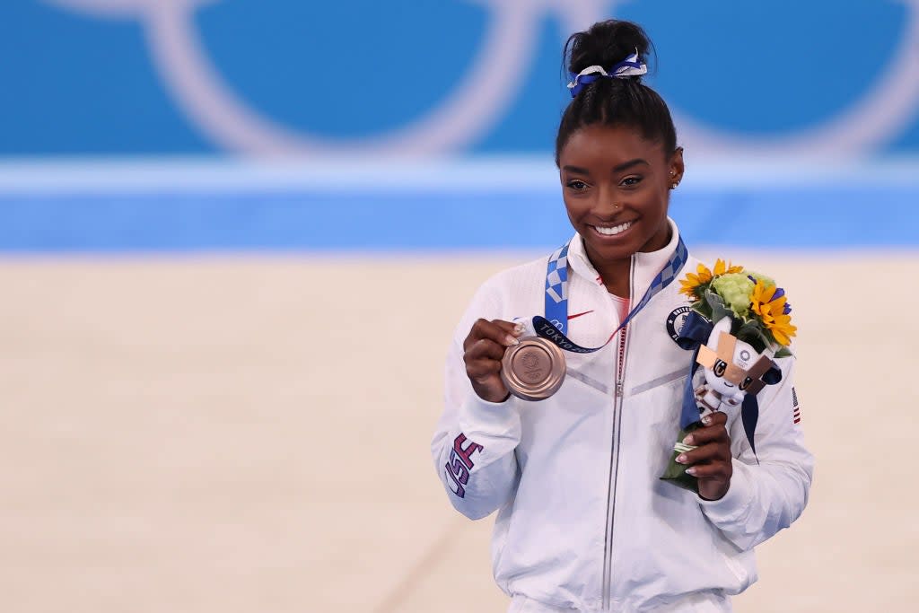 Simone Biles poses with her bronze medal, won in the beam final at Tokyo 2020 on 3 August (Getty Images)
