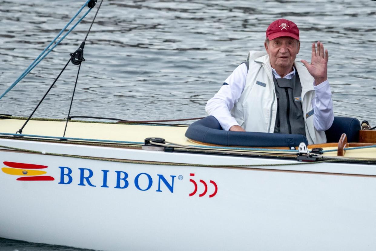 TOPSHOT - Spain's former King Juan Carlos I waves from his "Bribon" boat, as he attends the regatta of the InterRias trophy of 6M Spanish Cup, in the Galician town of Sanxenxo, northwestern Spain, on May 21, 2022. - Spain's former king returned to the country on May 19, 2022 for his first visit since he left nearly two years ago following a string of financial scandals. (Photo by Brais Lorenzo / AFP) (Photo by BRAIS LORENZO/AFP via Getty Images)