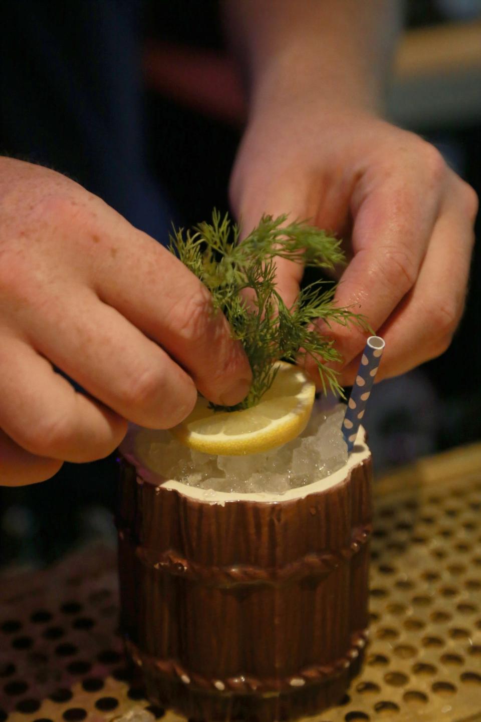 Andrew Jay Ripley, co-owner of Sea Wolf and Lone Wolf, adds garnish to a Samoan Dill Weed cocktail at Sea Wolf on Tybee Island.