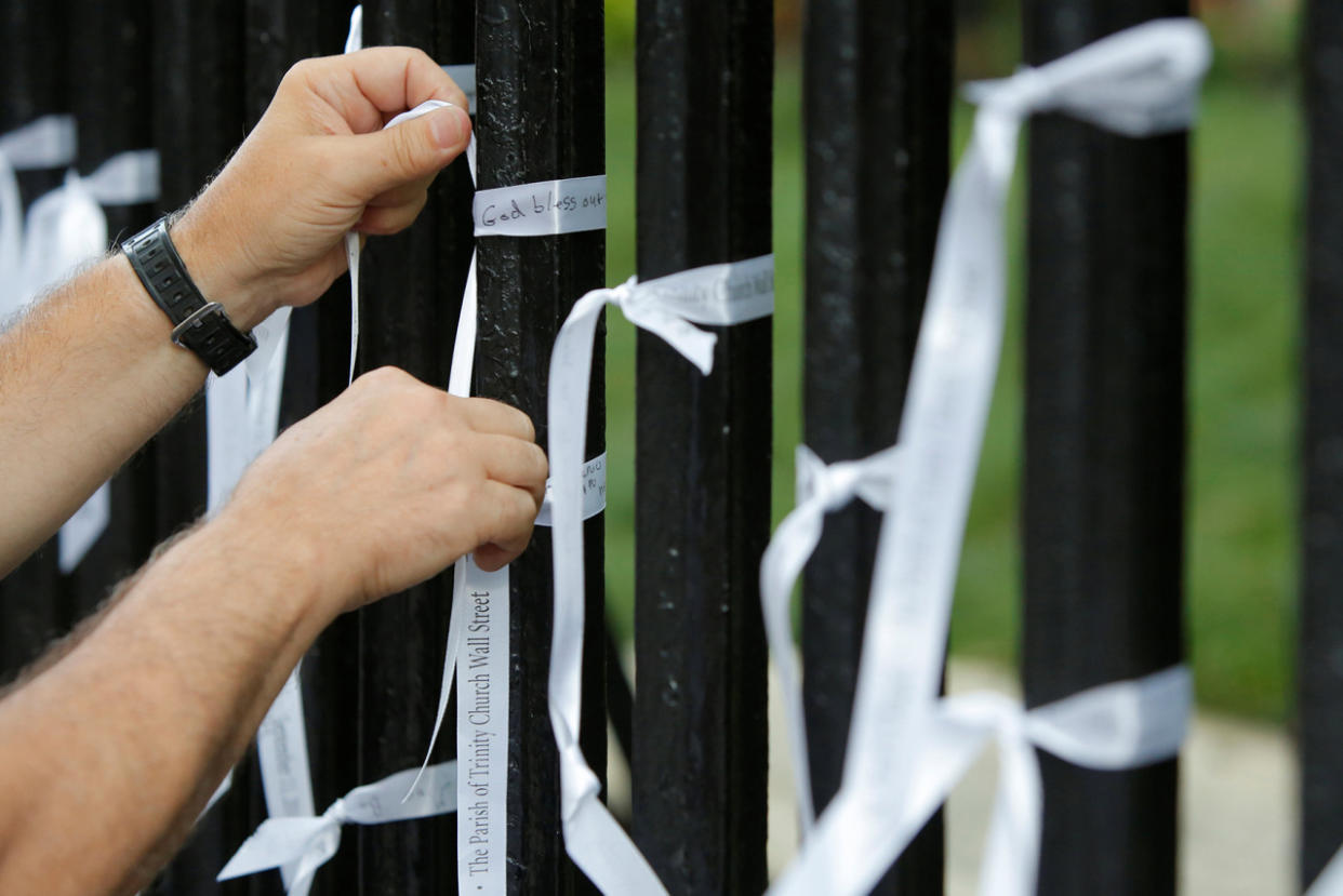 A man ties a memorial ribbon to the exterior wall of St. Paul's Chapel on the morning of the 15th anniversary of the 9/11 attacks in Manhattan, New York, September 11, 2016. (REUTERS/Andrew Kelly)