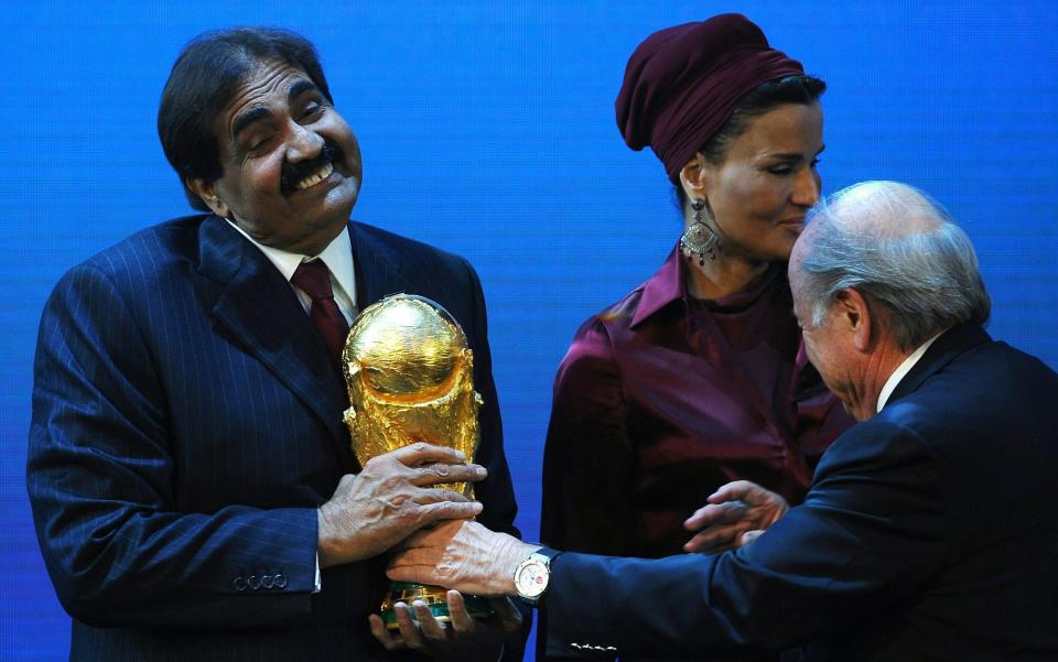 Qatari emir Sheikh Hamad bin Khalifa Al-Thani is presented with the World Cup Trophy by FIFA President Sepp Blatter  - Credit: Laurence Griffiths/Getty Images Sport