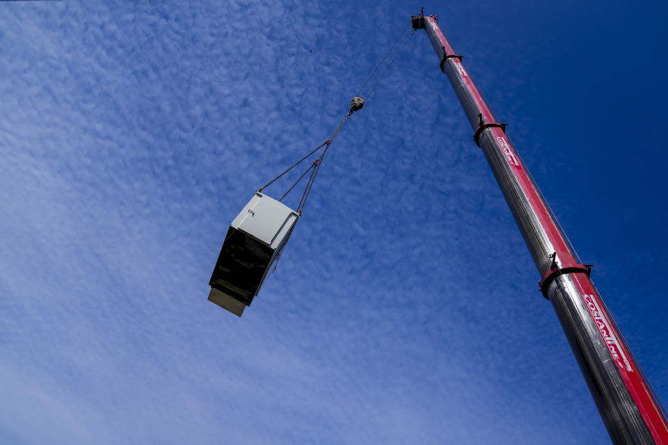 A new generator is lifted to a roof to replace an old generator in Beirut, Lebanon, Feb. 21, 2022. Private generators are ubiquitous in parts of the Middle East, spewing hazardous fumes into homes and business across the country, almost 24 hours a day. As the world looks for renewable energy to tackle climate change, Lebanon, Iraq, Gaza and elsewhere rely on diesel-powered private generators just to keep the lights on. The reason is state failure: In multiple countries, governments can’t maintain a functioning central power network, whether because of war, conflict or mismanagement and corruption. (AP Photo/Hassan Ammar)