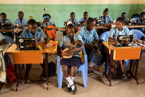 Ruth Sidi Karisa, 17, breastfeeds her six-month-old son Onesmus in the classroom - Credit: Simon Townsley/The Telegraph