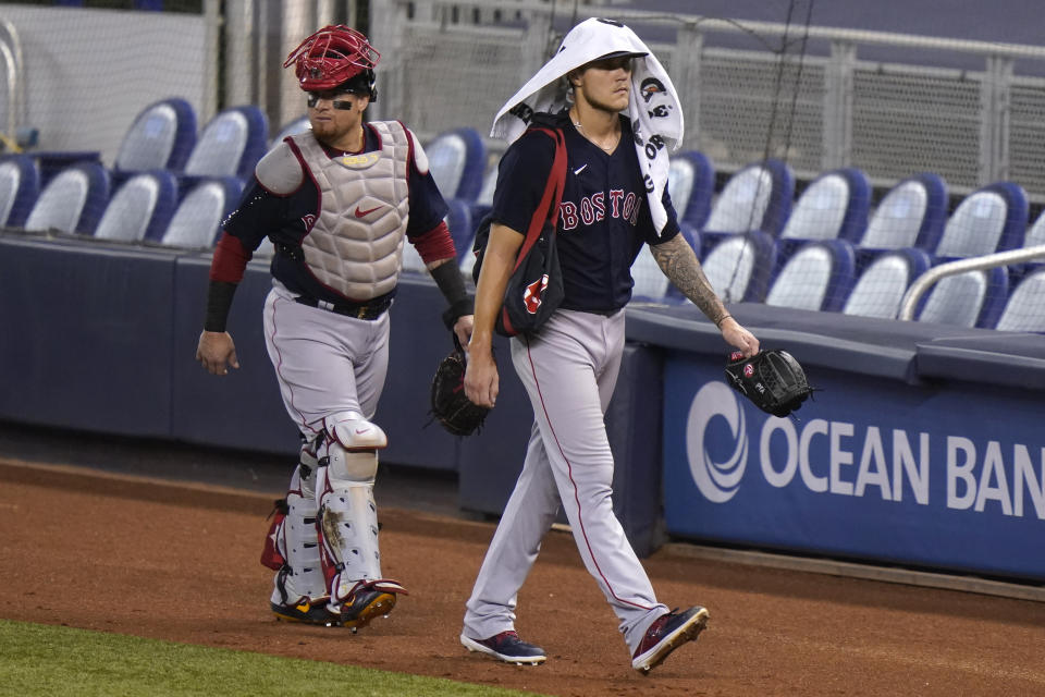 Boston Red Sox catcher Christian Vazquez, left, and starting pitcher Tanner Houck, right, walk to the dugout before a baseball game against the Miami Marlins, Tuesday, Sept. 15, 2020, in Miami. (AP Photo/Lynne Sladky)