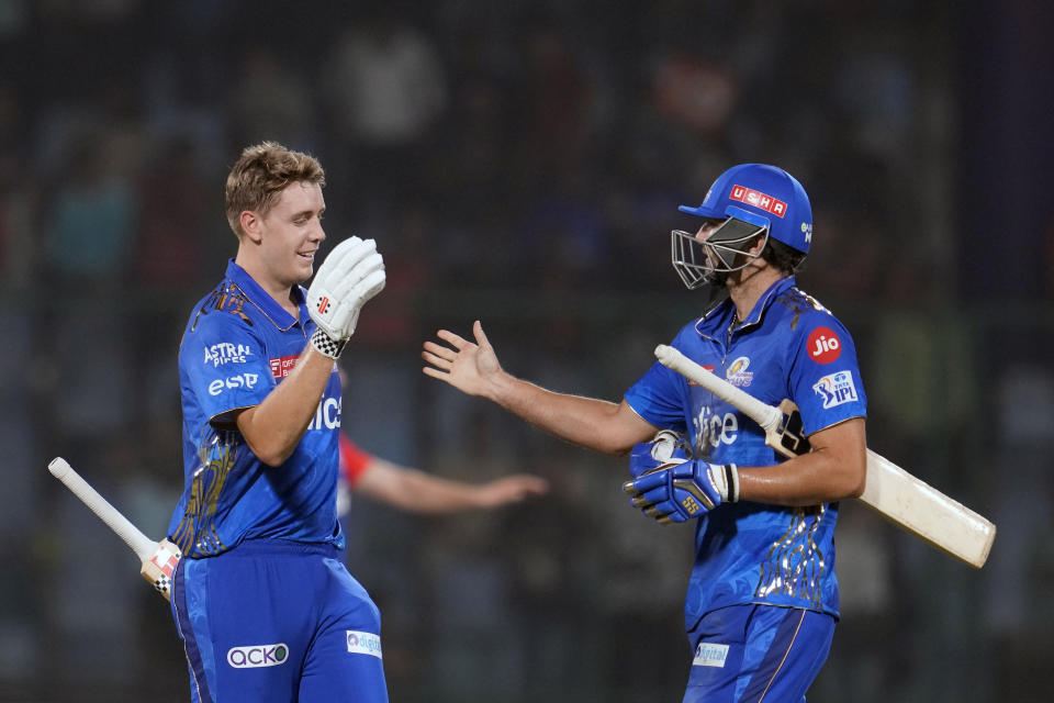 Mumbai Indians' Cameron Green, facing, and Tim David celebrate after winning the Indian Premier League (IPL) match against Delhi Capitals in New Delhi, India, Tuesday, April 11, 2023. (AP Photo/Manish Swarup)