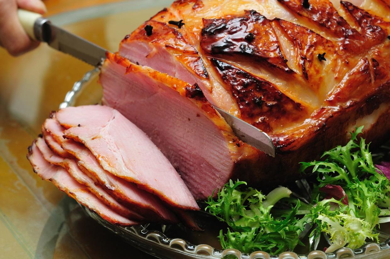 Slicing a smoked baked ham.