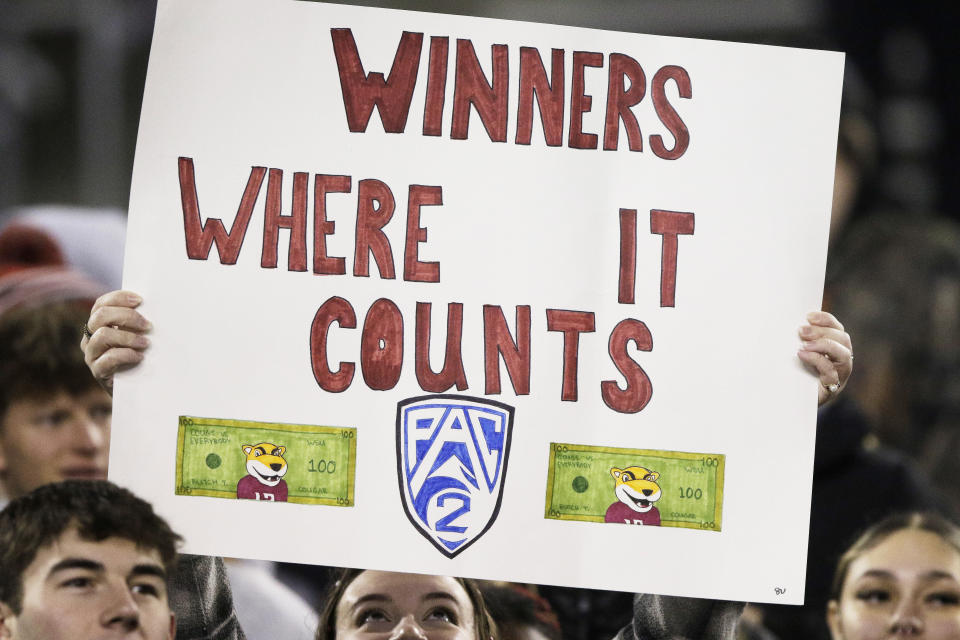 A Washington State fan holds a "Pac-2" sign before an NCAA college football game between Washington State and Colorado, Friday, Nov. 17, 2023, in Pullman, Wash. Washington State is one of two schools remaining in the Pac-12 after the 2023-2024 academic year after the other schools in the conference announced plans to leave. (AP Photo/Young Kwak)