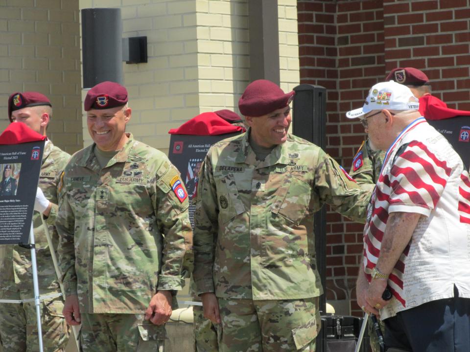 Joe Hill, far right, accepts an 82nd Airborne Division Hall of Fame recognition on behalf of his father, while congratulated by  Maj. Gen. Christopher LaNeve, far left and Command Sgt. Maj. Randolph Delapena, second from right,  during a ceremony Wednesday, May 24, 2023, at Fort Bragg.