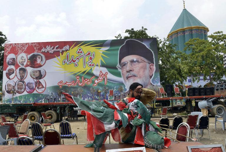 A Pakistani supporter of cleric Tahir-ul-Qadri collects party flags outside his residence in Lahore, on August 11, 2014