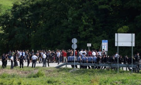 Migrants and Bosnian police are seen next to the border with Croatia in Velika Kladusa, picture taken from Maljevac, Croatia, June 18, 2018. REUTERS/Antonio Bronic