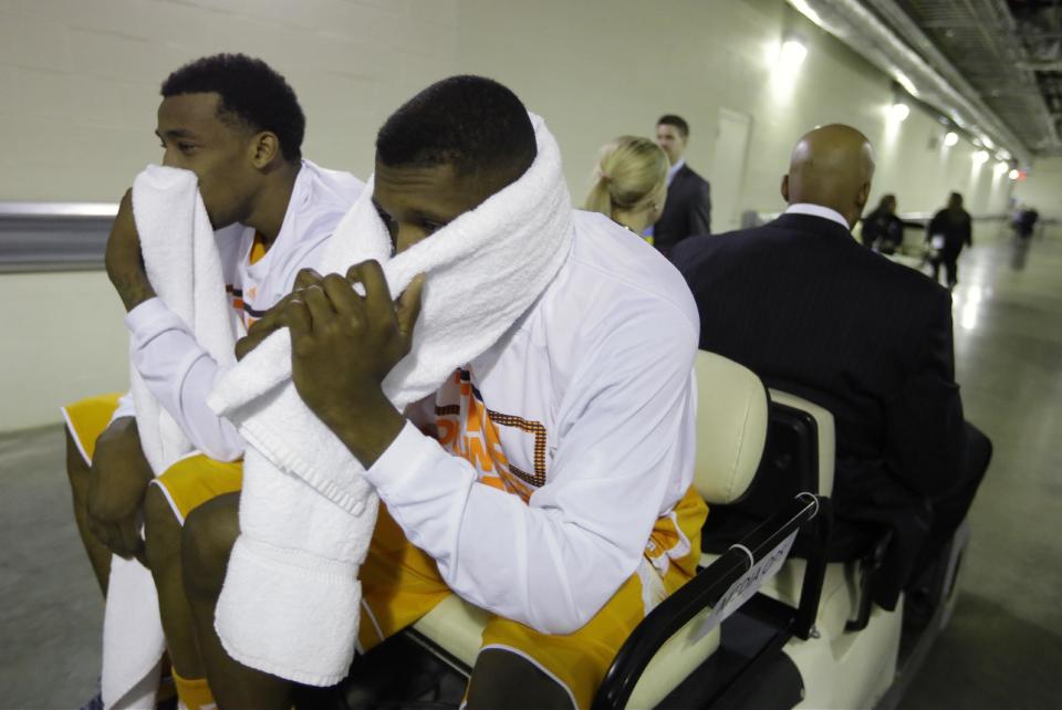 Tennessee guard Josh Richardson, left, and Jordan McRae look down in the cart as they head to the locker room after an NCAA Midwest Regional semifinal college basketball tournament game Friday, March 28, 2014, in Indianapolis. Michigan won 73-71. (AP Photo/Michael Conroy)