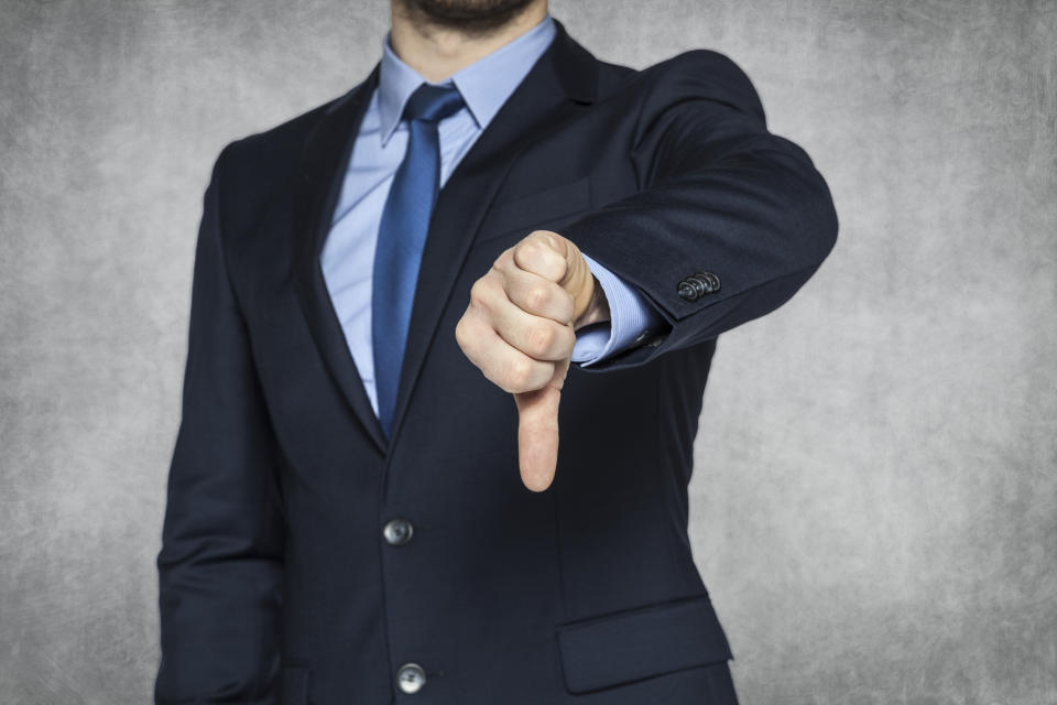 A businessman giving the thumbs-down sign.