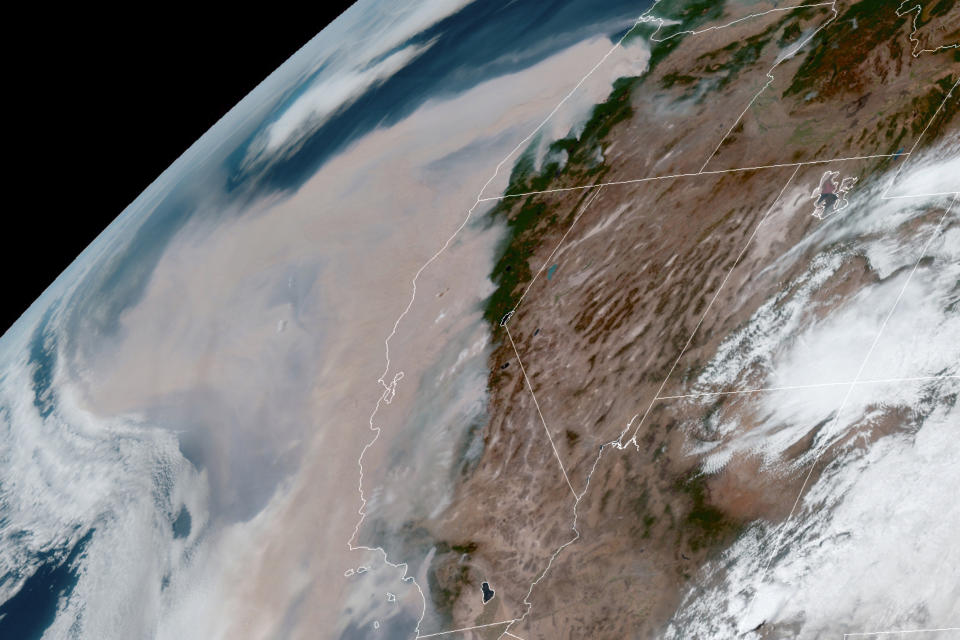 This GOES-16 GeoColor satellite image taken at 20:00 UTC (4 p.m. EDT) and provided by the National Oceanic and Atmospheric Administration (NOAA), shows brown smoke from wildfires blowing westward in the atmosphere from California's Sierra Nevada to the Coast Ranges and from Oregon, top, on Wednesday, Sept. 9, 2020. (NOAA via AP)