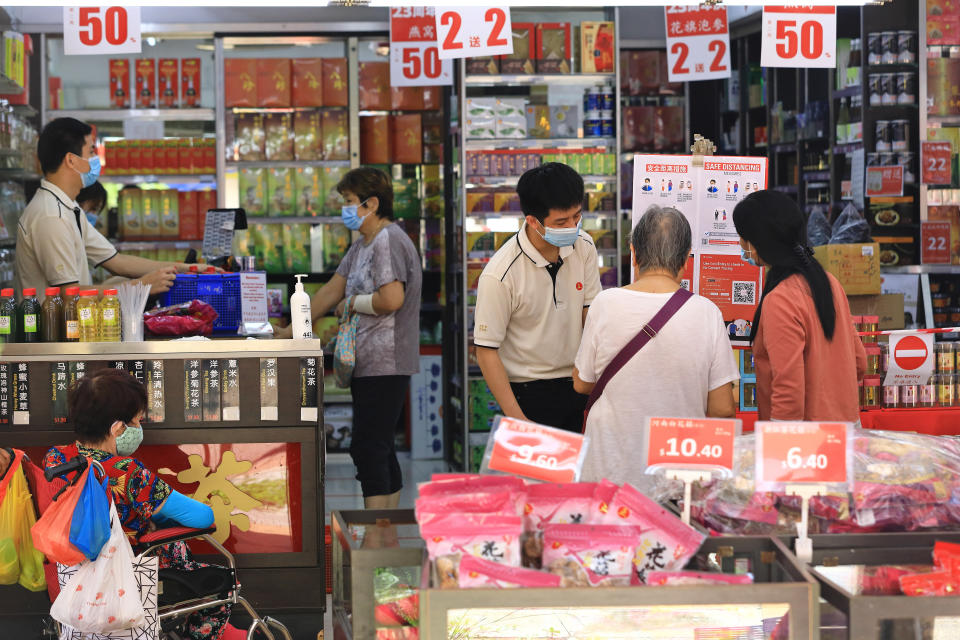 People wearing protective masks shop in a store selling TCM products here on 12 May, 2020. (PHOTO: Getty Images)