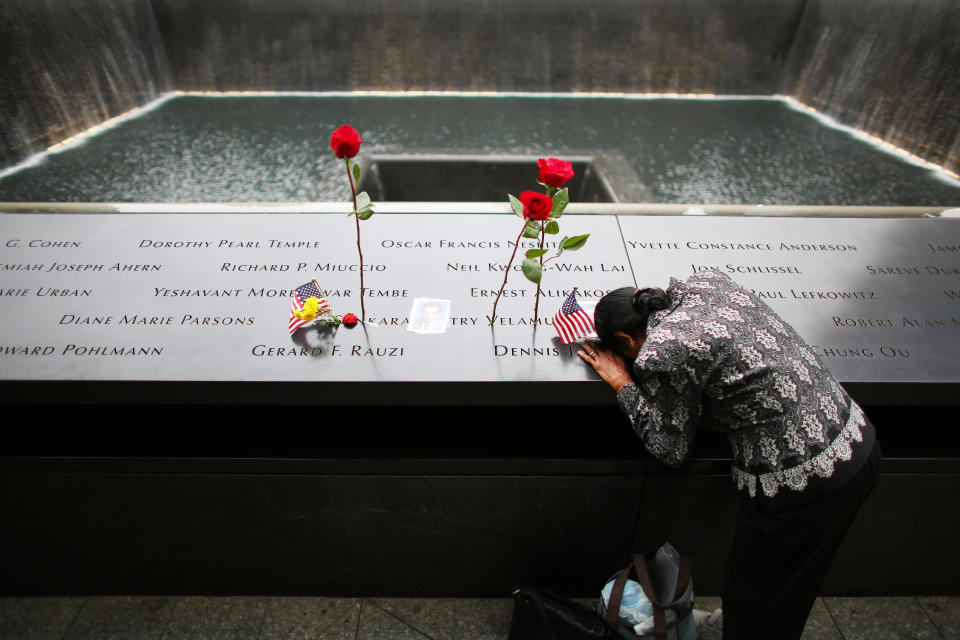 NEW YORK, NY - SEPTEMBER 11: A woman grieves at her husband's memorial at South Tower Reflecting Pool before the memorial observances held at the site of the World Trade Center before memorial observances are held at the site of the World Trade Center on September 11, 2014 in New York City. This year marks the 13th anniversary of the September 11th terrorist attacks that killed nearly 3,000 people at the World Trade Center, Pentagon and on Flight 93.  (Photo by Chang W. Lee-Pool/Getty Images)