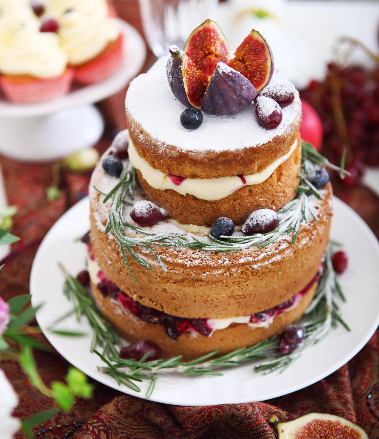 Dessert table for a wedding. Cake, cupcakes, sweetness, fruits and flowers. Close up