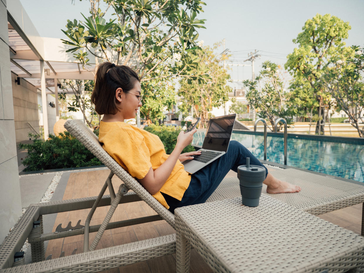 Digital nomad working near the pool. (Photo: Gettyimages)