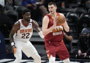 Denver Nuggets center Nikola Jokic, right, looks to pass the ball as Phoenix Suns center Deandre Ayton defends in the first half of Game 4 of an NBA second-round playoff series Sunday, June 13, 2021, in Denver. (AP Photo/David Zalubowski)