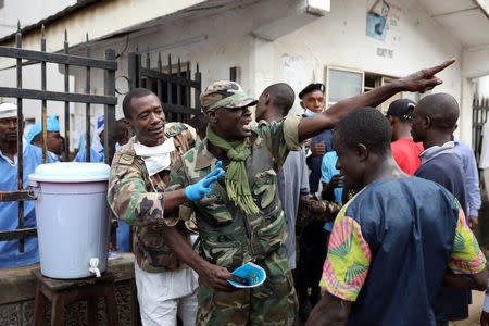 A military member directs the crowd at the entrance of Connaught Hospital in Freetown, Sierra Leone August 16, 2017. REUTERS/Afolabi Sotunde