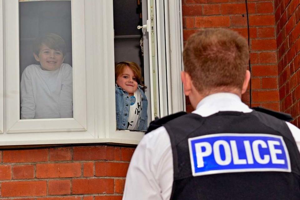 Dexter Lee, alongside big brother Freddi, being greeted by Sergeant Mark Wilson (PA)