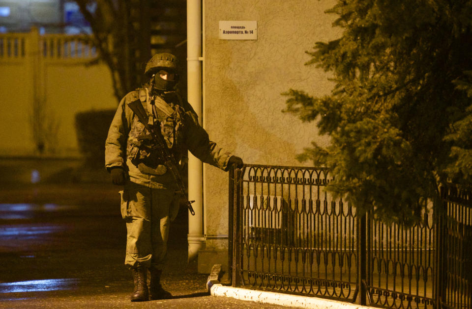 An unidentified armed man guards a building at the airport in Simferopol, Ukraine, Friday, Feb. 28, 2014. Dozens of armed men in military uniforms without markings patroled the airport in the capital of Ukraine's strategic Crimea region. (AP Photo/Ivan Sekretarev)