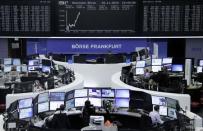 Traders are pictured at their desks in front of the DAX board at the stock exchange in Frankfurt, Germany, November 25, 2015. REUTERS/Staff/Remote