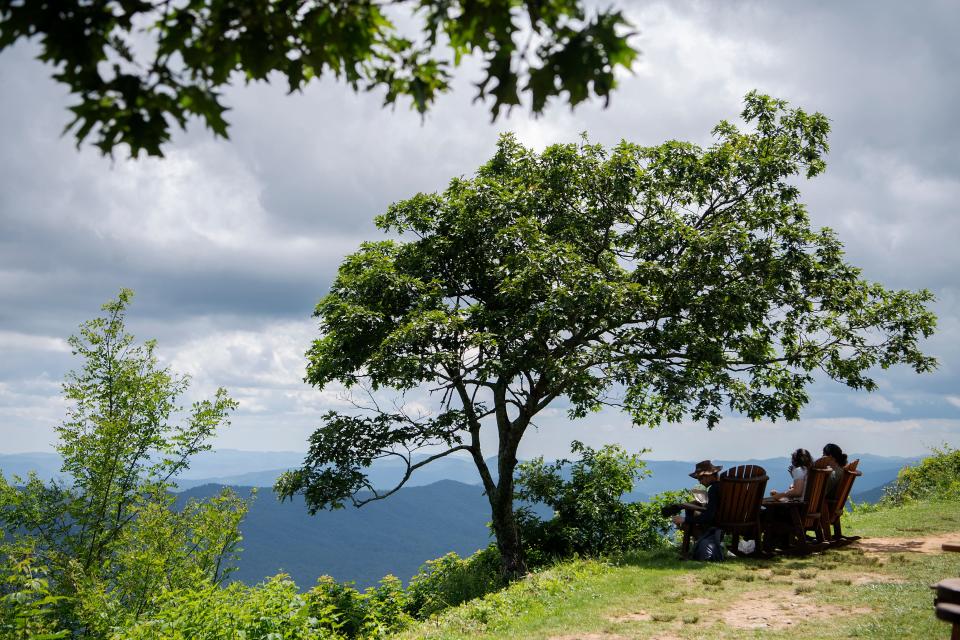 From left: D.J. Rodell, Julia Hudgins and Dylan Lossiah, all of Sylva, enjoy takeout on chairs overlooking the mountains at the Pisgah Inn on the Blue Ridge Parkway on July 13, 2020. 