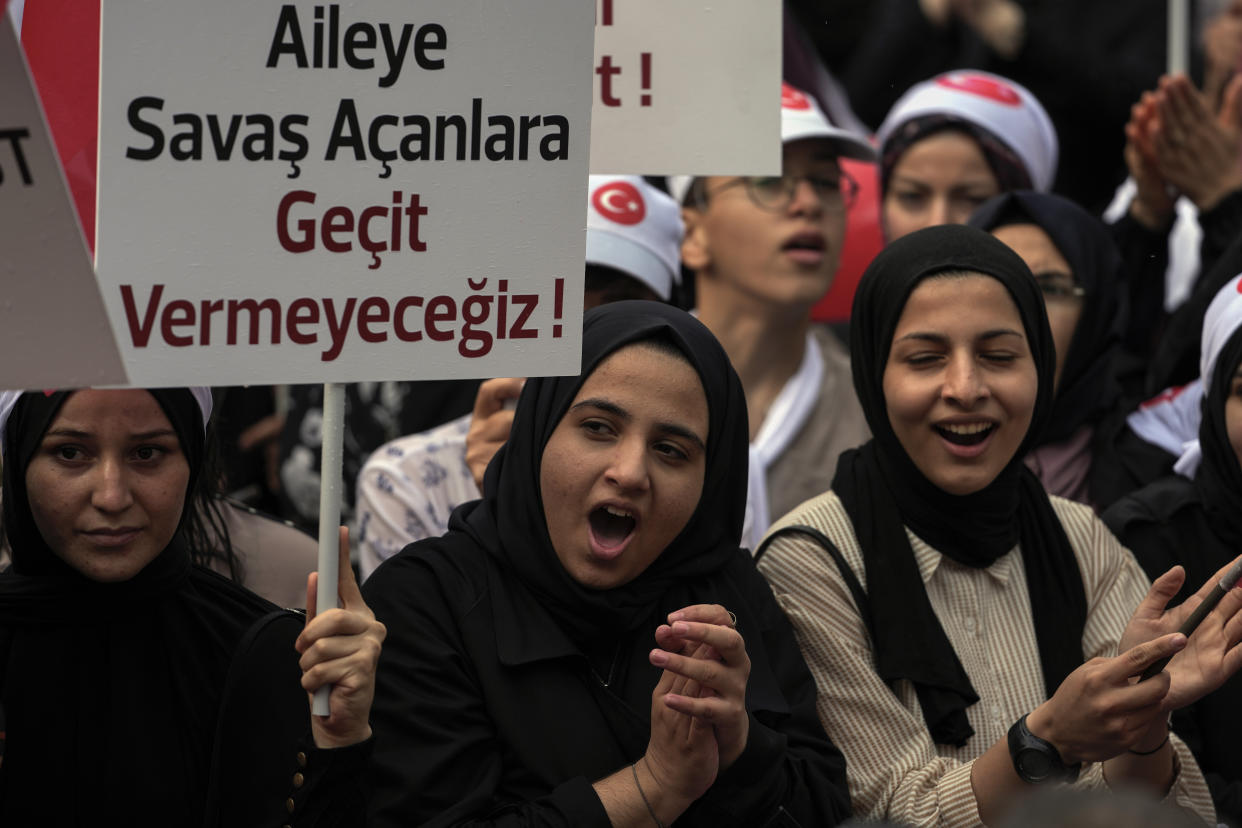 Turkish demonstrators chant slogans while holding a banner that reads: "We will not give way to those who wage war on the family", in the Fatih district of Istanbul, Sunday, Sept. 18, 2022. (AP Photo/Khalil Hamra)