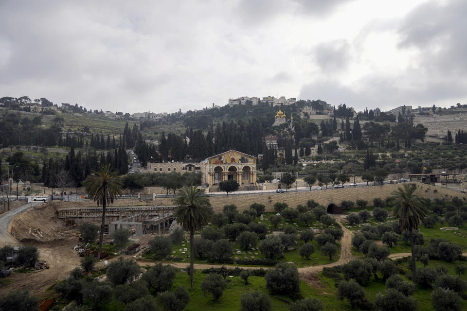 Clouds hover over the Mount of Olives and the Church of All Nations in the Garden of Gethsemane, in East Jerusalem, Monday, Feb. 21, 2022. Israel's Nature and Parks Authority says it is backing down from a plan to encompass Christian holy sites on Jerusalem's Mount of Olives in a national park after vociferous outcry from major churches. (AP Photo/Mahmoud Illean)