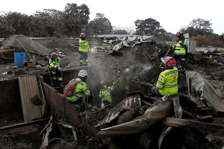 Guatemalan rescue workers continue looking for families in an area affected by the eruption of the Fuego volcano in San Miguel Los Lotes in Escuintla, Guatemala June 13, 2018. REUTERS/Carlos Jasso