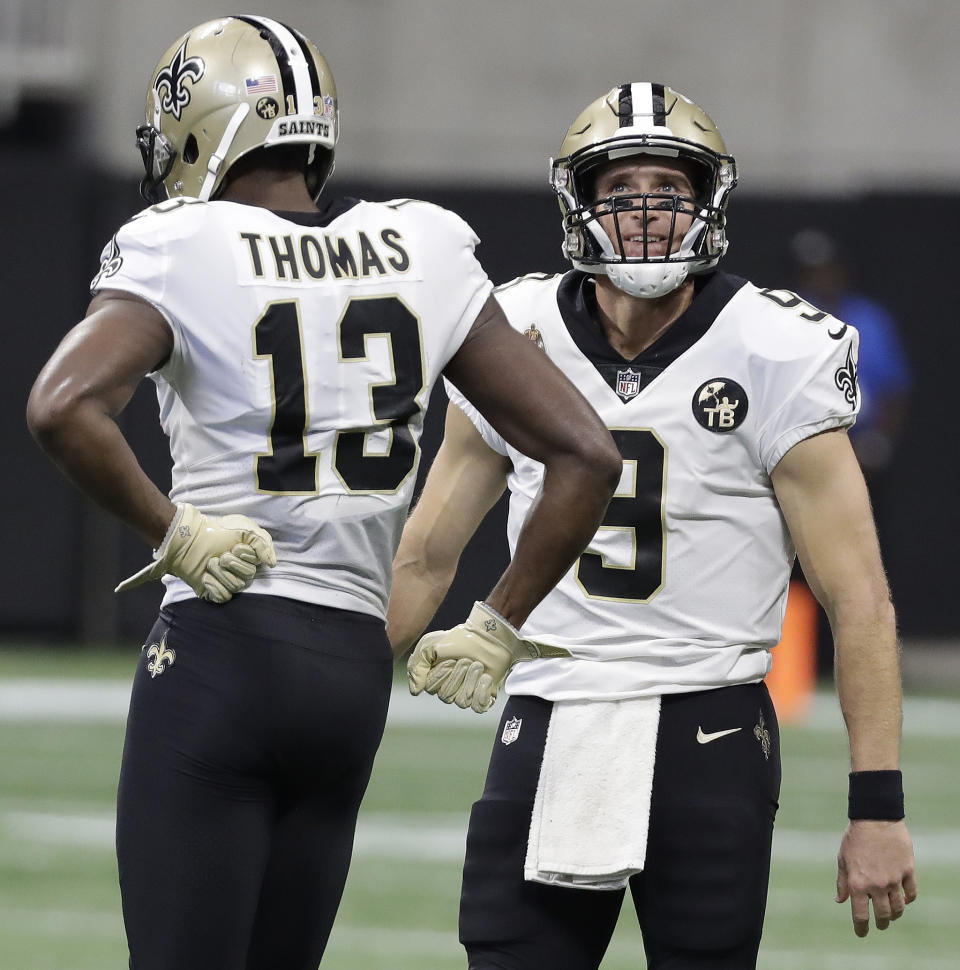 New Orleans Saints quarterback Drew Brees (9) celebrates his pass to New Orleans Saints wide receiver Michael Thomas (13) against the Atlanta Falcons during the first half of an NFL football game, Sunday, Sept. 23, 2018, in Atlanta. Brees' pass competition to Thomas for 17 yards broke Brett Favre's record for most past completions in a career with his 6,301 completion. (AP Photo/Mark Humphrey)